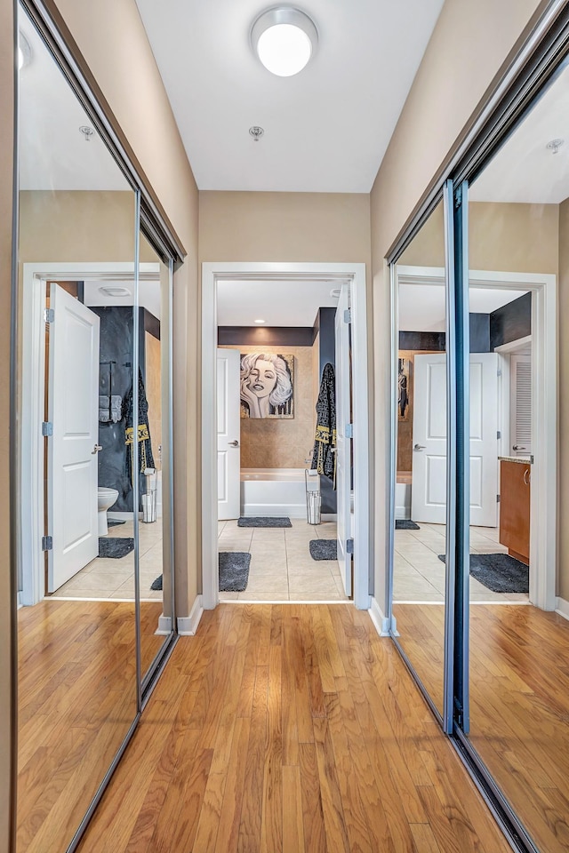 hallway with light wood-style floors and baseboards