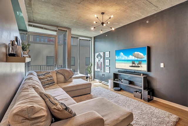 living area with baseboards, an inviting chandelier, and wood finished floors