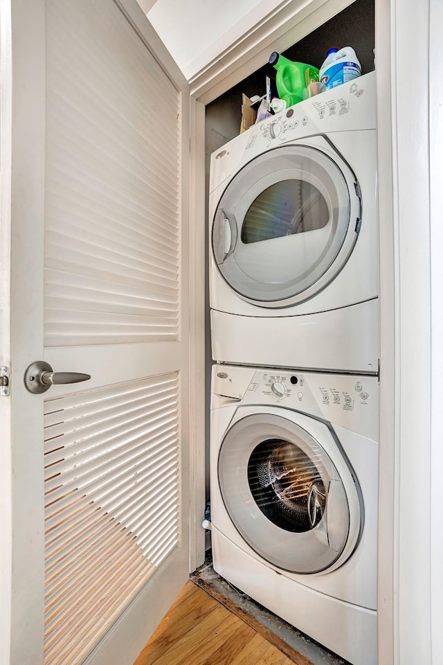 laundry area featuring laundry area, stacked washer / dryer, and wood finished floors