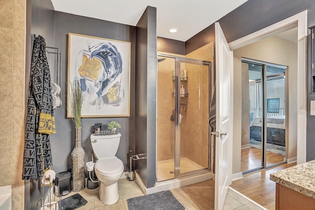 bathroom featuring vanity, baseboards, a stall shower, tile patterned flooring, and toilet