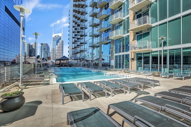 community pool featuring a patio area and a view of city