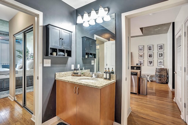 bathroom featuring vanity, ensuite bath, baseboards, and wood-type flooring