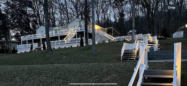 view of front of house featuring stairs, a front yard, and a deck