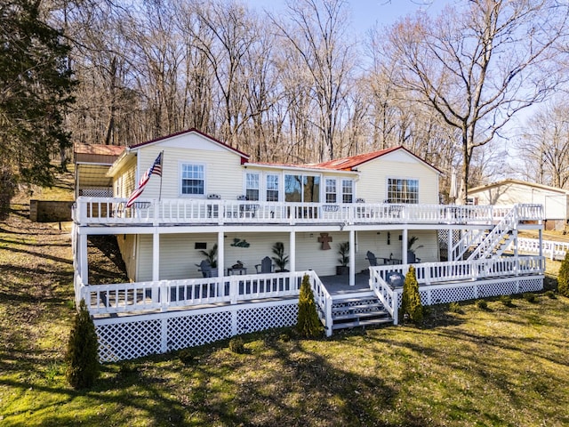 rear view of property with a lawn and a deck