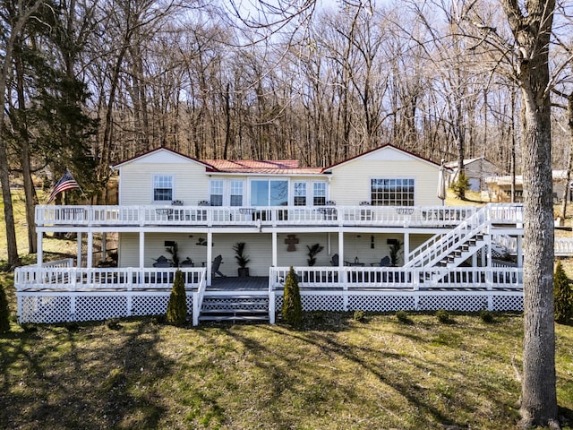 back of property with a lawn and a wooden deck