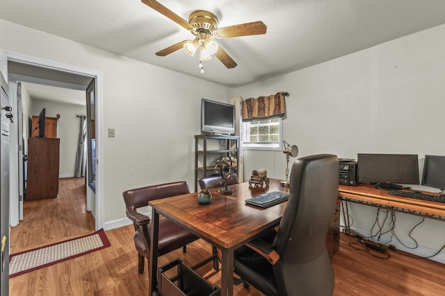 dining space with a ceiling fan, wood finished floors, and baseboards