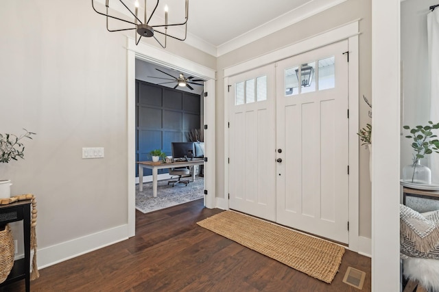 foyer featuring visible vents, dark wood-type flooring, baseboards, ornamental molding, and an inviting chandelier