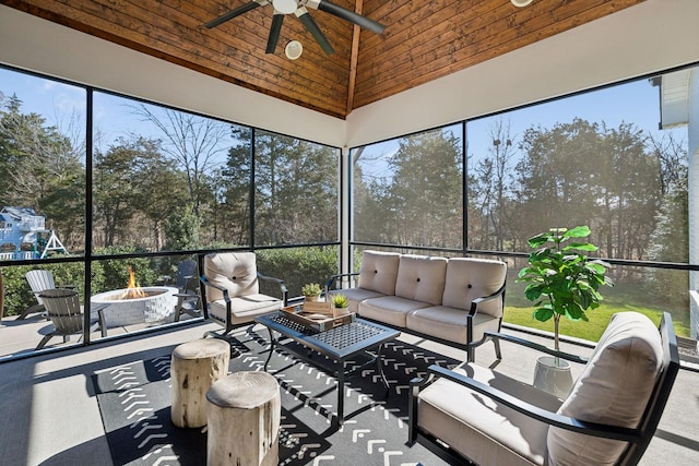 unfurnished sunroom featuring wood ceiling, a ceiling fan, and lofted ceiling