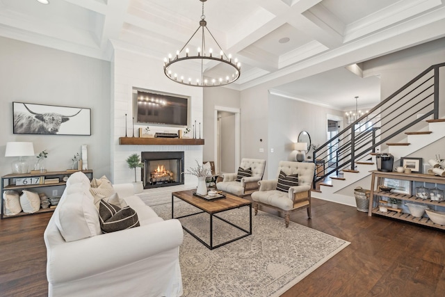 living room featuring a notable chandelier, coffered ceiling, stairs, and wood finished floors