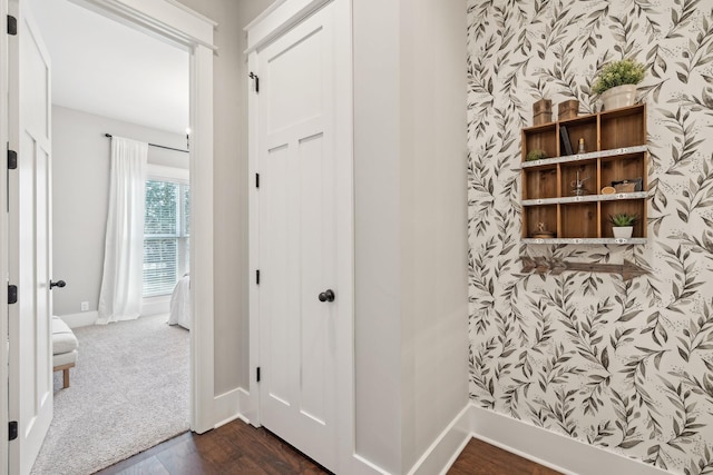 hallway with wallpapered walls, dark wood finished floors, and baseboards