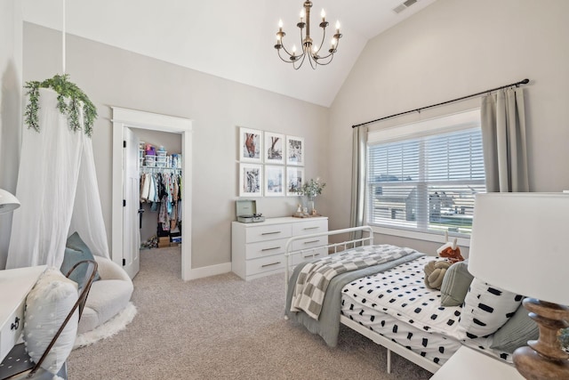 bedroom with baseboards, an inviting chandelier, vaulted ceiling, a walk in closet, and light colored carpet