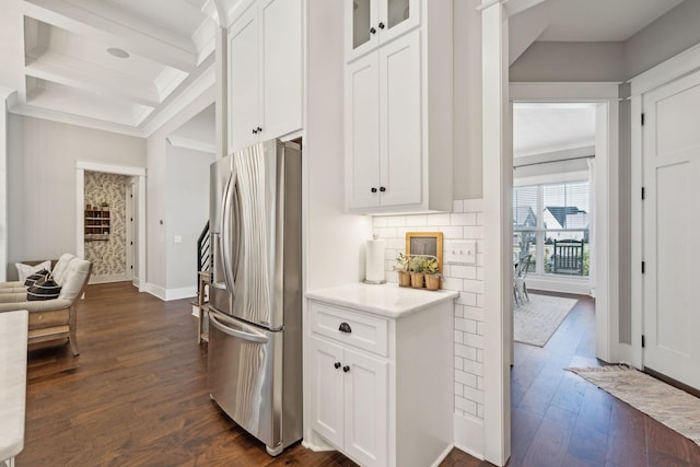 kitchen featuring dark wood-type flooring, coffered ceiling, tasteful backsplash, white cabinetry, and stainless steel fridge with ice dispenser