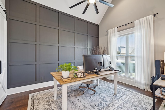 office area featuring visible vents, a ceiling fan, dark wood finished floors, a decorative wall, and vaulted ceiling