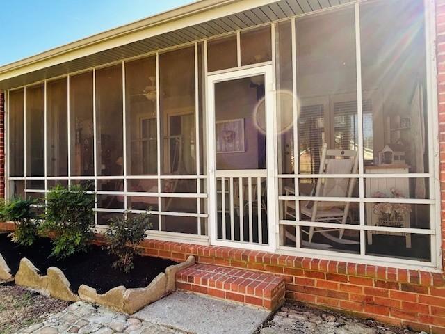 view of side of property with brick siding and a sunroom