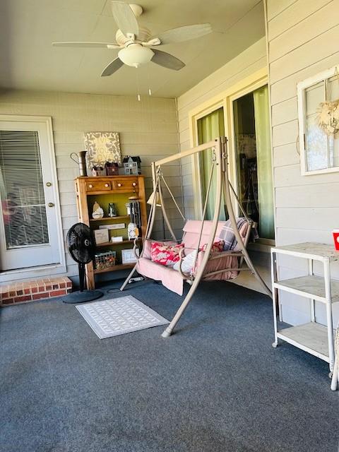 sunroom / solarium featuring a ceiling fan