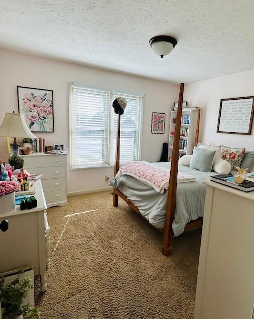 bedroom featuring light carpet and a textured ceiling