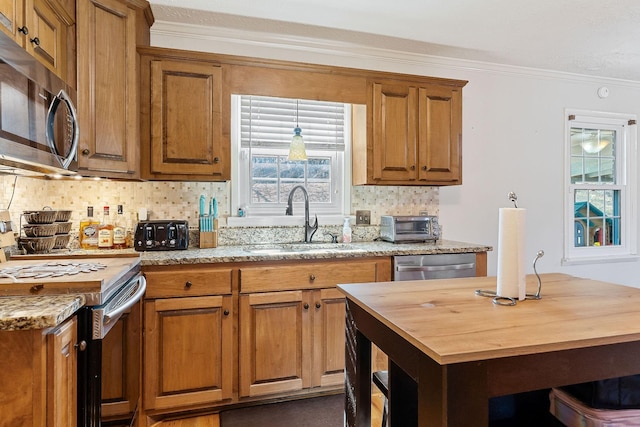 kitchen featuring ornamental molding, a sink, wood counters, backsplash, and appliances with stainless steel finishes