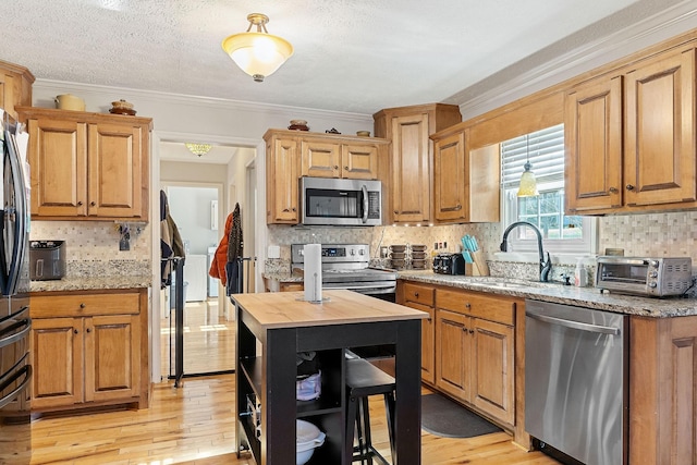 kitchen with a toaster, light wood-type flooring, appliances with stainless steel finishes, and butcher block countertops