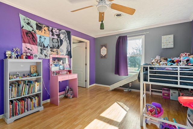 bedroom with visible vents, baseboards, ornamental molding, wood finished floors, and a textured ceiling