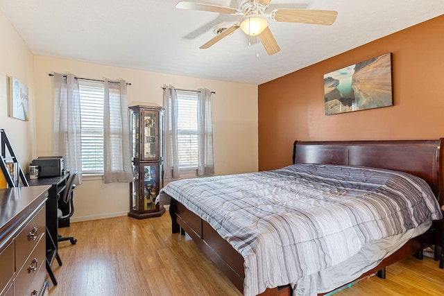 bedroom featuring multiple windows, baseboards, light wood-style floors, and ceiling fan