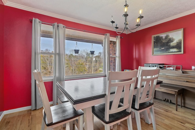 dining area with a notable chandelier, ornamental molding, a textured ceiling, and wood finished floors