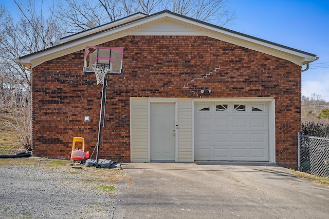 garage with aphalt driveway and fence