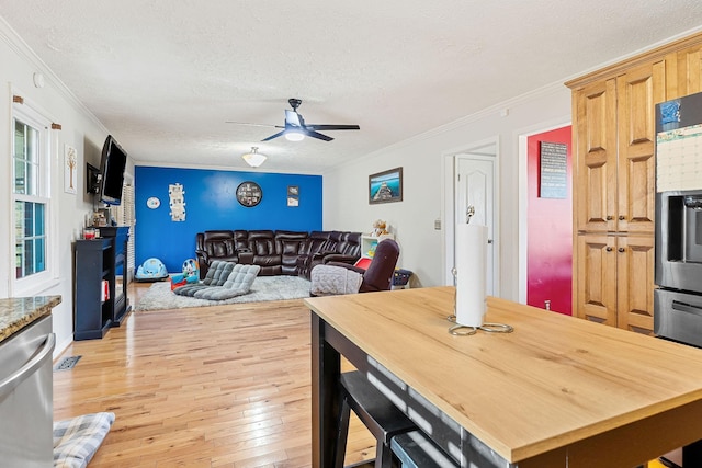 dining space featuring light wood-type flooring, a textured ceiling, ceiling fan, and crown molding