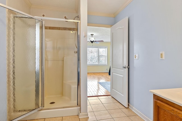 full bathroom with ceiling fan, a stall shower, crown molding, and tile patterned flooring