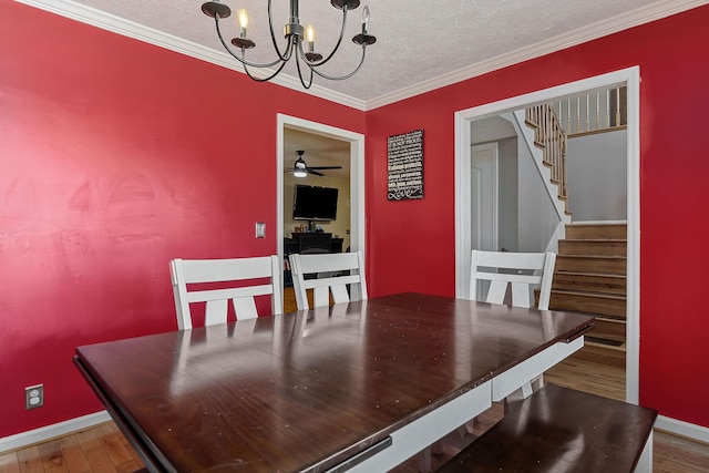 dining area with stairway, wood finished floors, baseboards, a textured ceiling, and crown molding