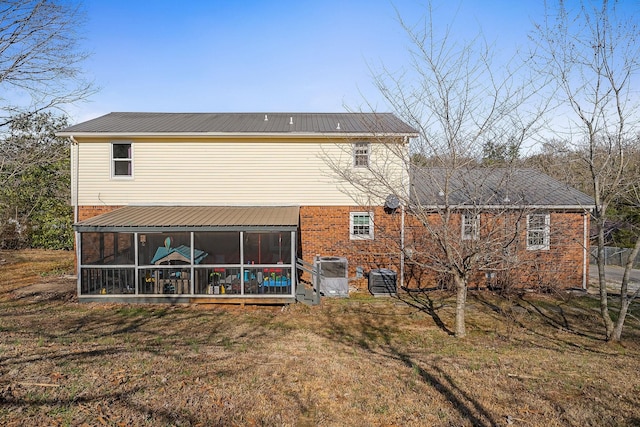 back of house with metal roof, a lawn, central AC unit, and a sunroom