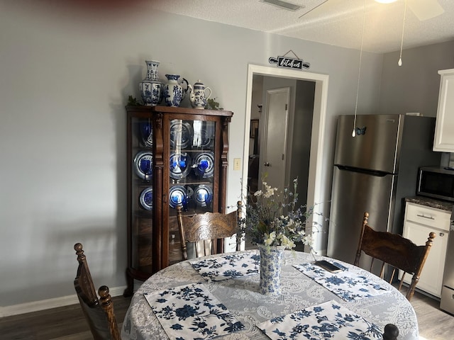 dining space featuring visible vents, wood finished floors, and baseboards