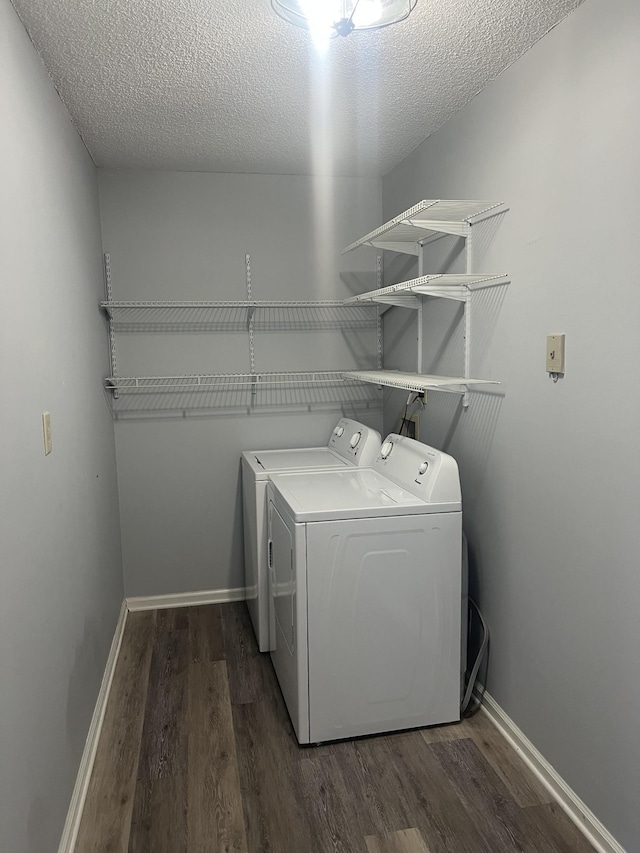 laundry room with washer and clothes dryer, laundry area, dark wood finished floors, and baseboards