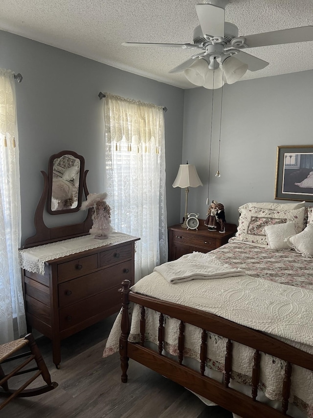 bedroom featuring dark wood finished floors, a textured ceiling, and a ceiling fan