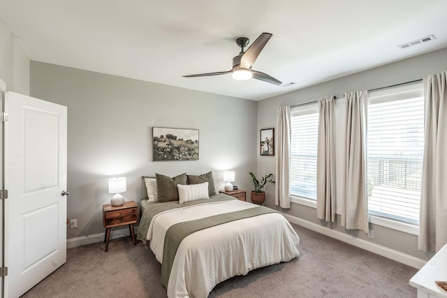 bedroom with multiple windows, light colored carpet, and visible vents