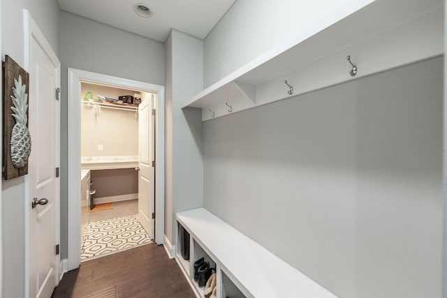 mudroom featuring dark wood-type flooring and baseboards