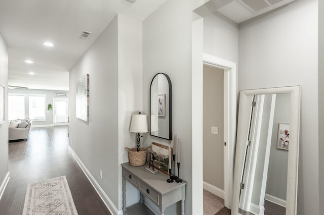 hallway featuring dark wood finished floors, visible vents, recessed lighting, and baseboards