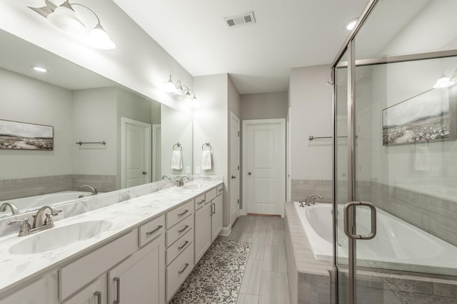 full bath with a garden tub, double vanity, visible vents, and a sink