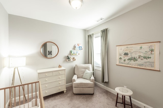 carpeted bedroom featuring visible vents, baseboards, and a nursery area