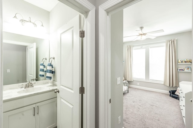 bathroom with ceiling fan, vanity, and baseboards