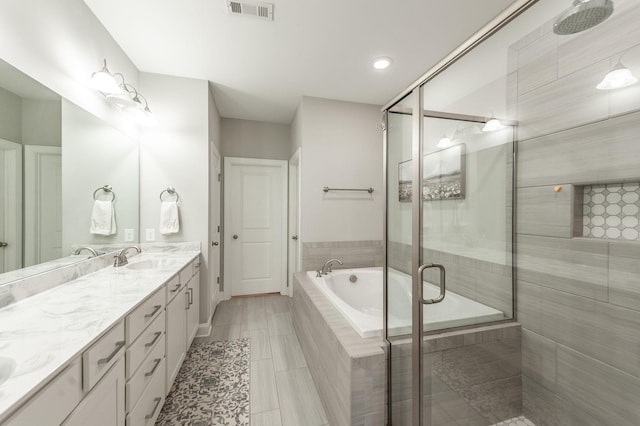 full bath featuring visible vents, double vanity, a sink, a shower stall, and a bath