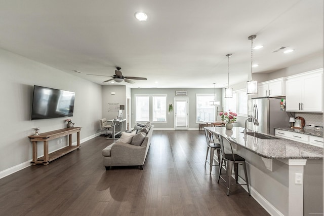 living area with visible vents, a ceiling fan, dark wood-style floors, recessed lighting, and baseboards