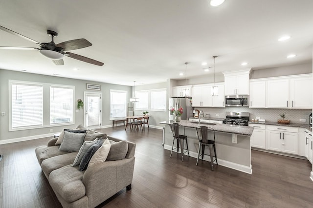 living area featuring ceiling fan, baseboards, dark wood-style floors, and recessed lighting