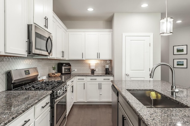 kitchen featuring a sink, appliances with stainless steel finishes, dark wood-style floors, and white cabinetry