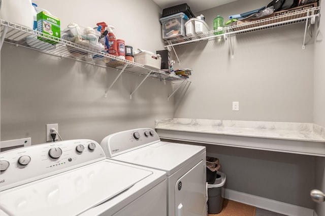 washroom with baseboards, washing machine and dryer, and laundry area