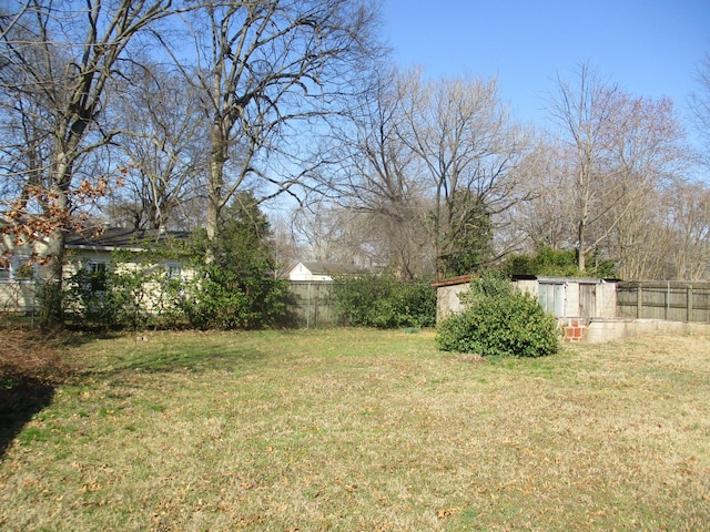 view of yard featuring a storage shed, an outdoor structure, and fence