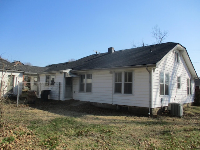 back of house with a lawn, cooling unit, a chimney, and fence