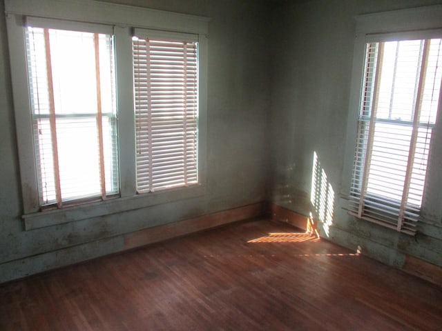 empty room featuring baseboards and wood finished floors