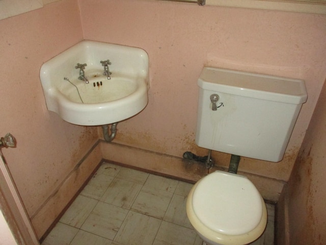 half bathroom featuring toilet and a sink