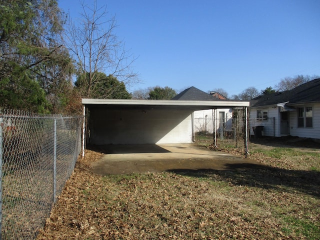 view of outdoor structure with a carport and fence