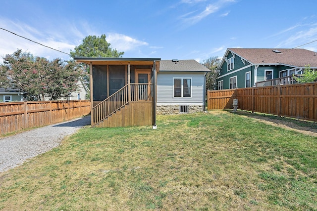 rear view of house featuring a yard, a fenced backyard, and driveway